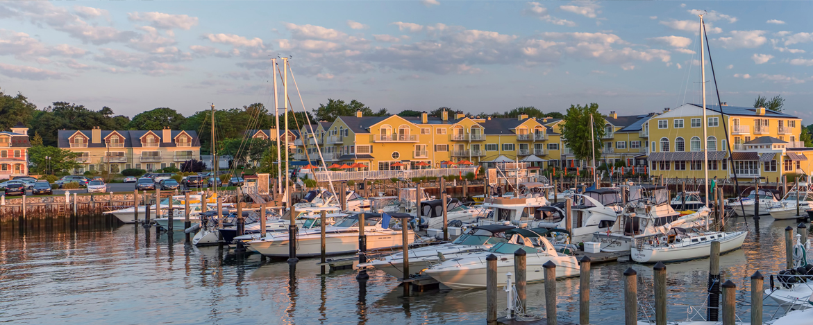 boats docked in a pretty harbor at sunset