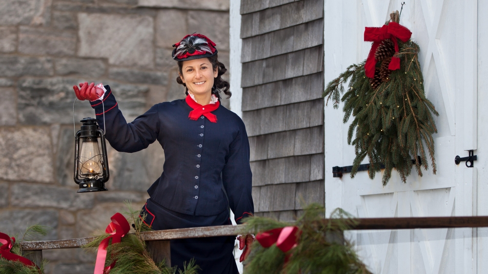 Woman holding lantern at Mystic Seaport